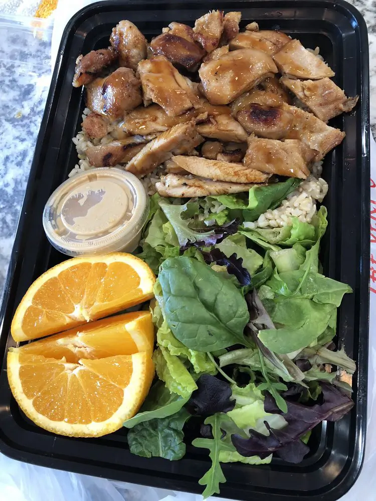 Light meal set in a black container, including grilled chicken breast, brown rice, fresh salad, orange slices and a small dip at Yummy Hawaiian BBQ, a Hawaiian Restaurant in Petaluma